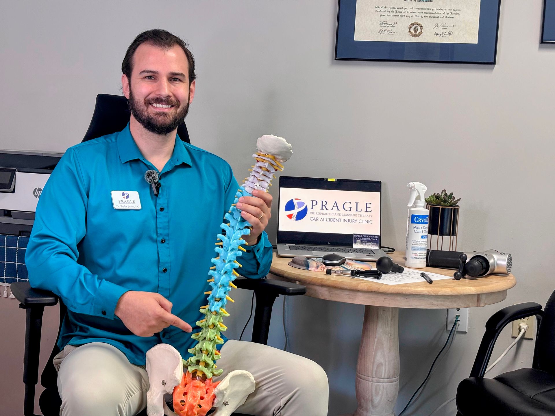Chiropractor holding spine model, demonstrating expertise in auto injury treatment